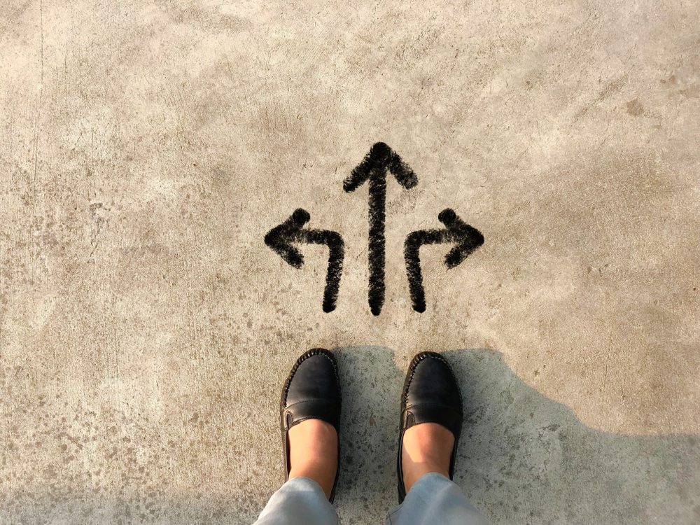 woman's feet standing over three arrows pointing in different directions