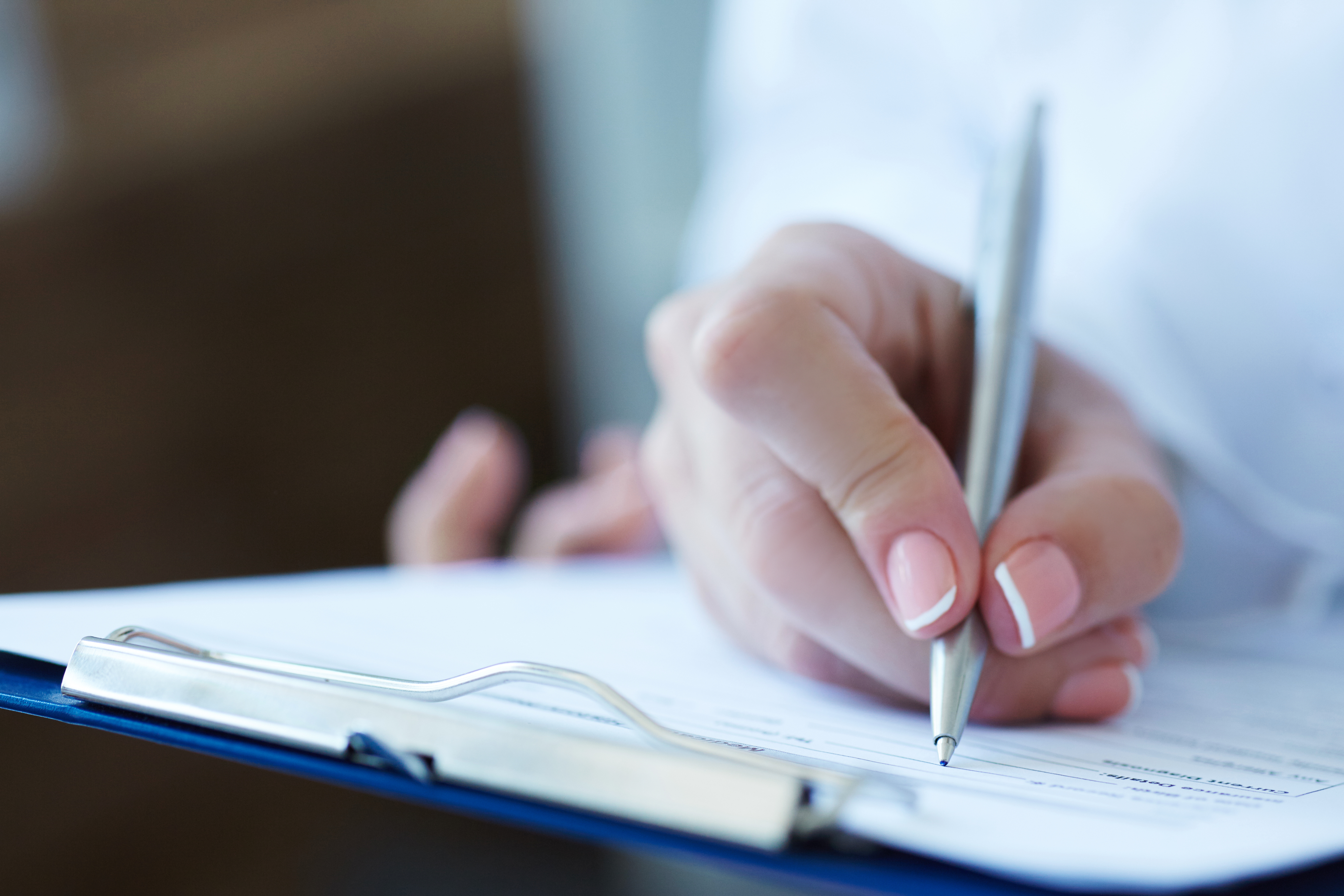Person writing on form