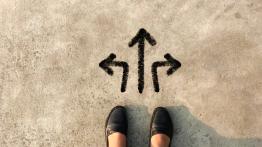 woman's feet standing over three arrows pointing in different directions