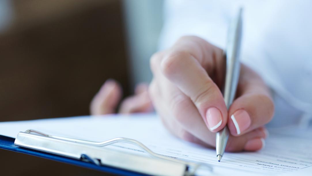 person writing on form